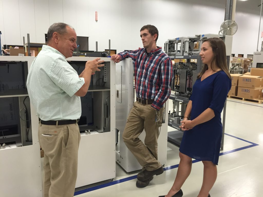 From left, clockwise, Mack Molding President Jeff Somple discusses one of the Company’s new programs with Finishing Technician Matt Comar and Program Coordinator Britney Coley. Comar and Coley are former interns who have recently returned to Mack as full-time employees. 