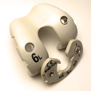 Picture illustrating the Overmolding and Insert Molding process by showing orthopedic parts with stainless steel bushings inserted into them.