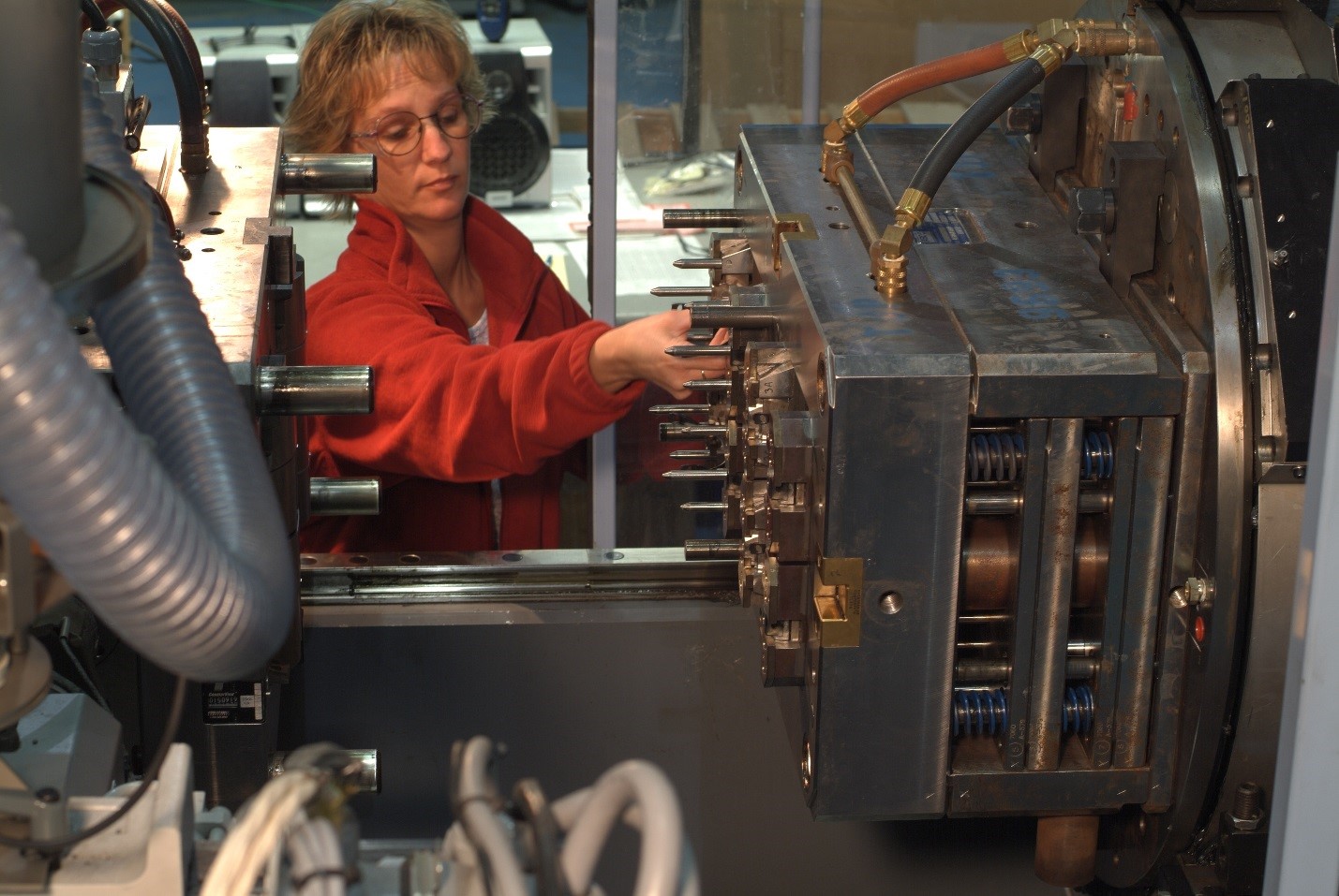 Image showing molder taking part out of a tool. Custom Injection Molding.